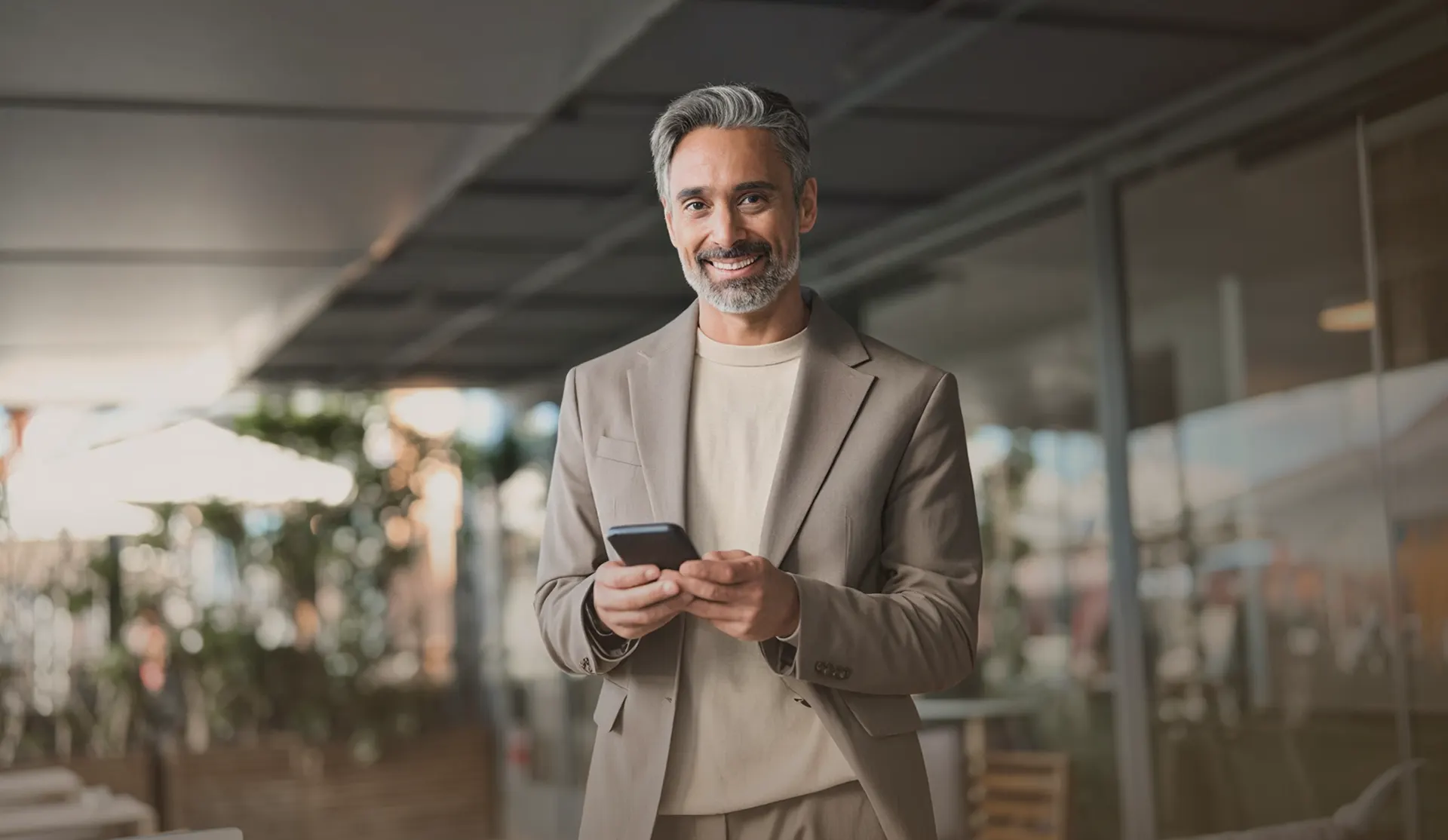 Executivo consultando o celular em um escritório iluminado